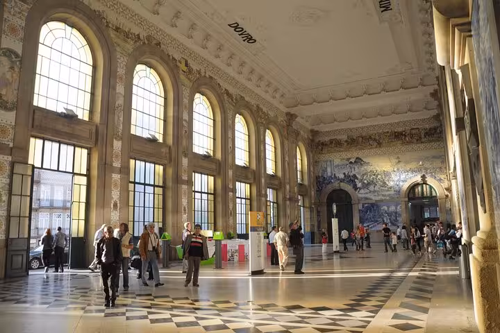 Beautiful interior of São Bento Station in Porto featuring iconic azulejo tiles, ideal stop on e-bike tours with locals.