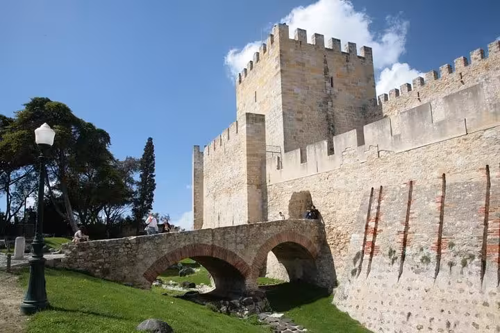 Majestic São Jorge Castle in Lisbon with ancient stone walls and lush greenery, perfect for private tours.