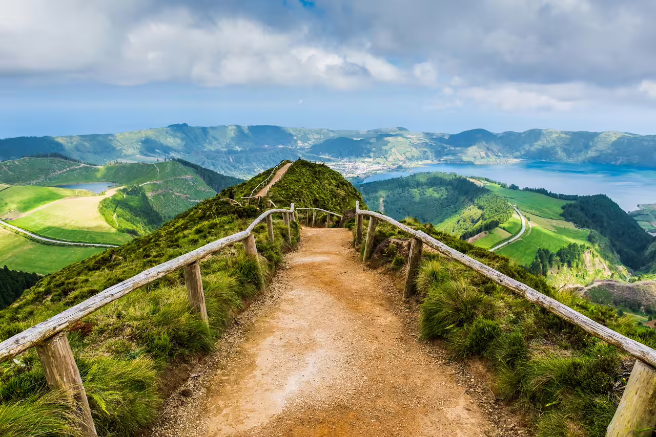Scenic hiking trail along lush green hills overlooking Sete Cidades Lake on São Miguel Island in the Azores.