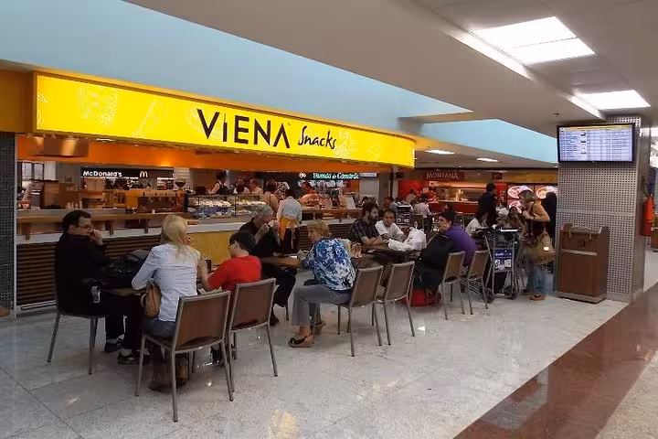 Travelers relaxing at Viena Snacks in São Paulo airport before shuttle to Paraty departs.