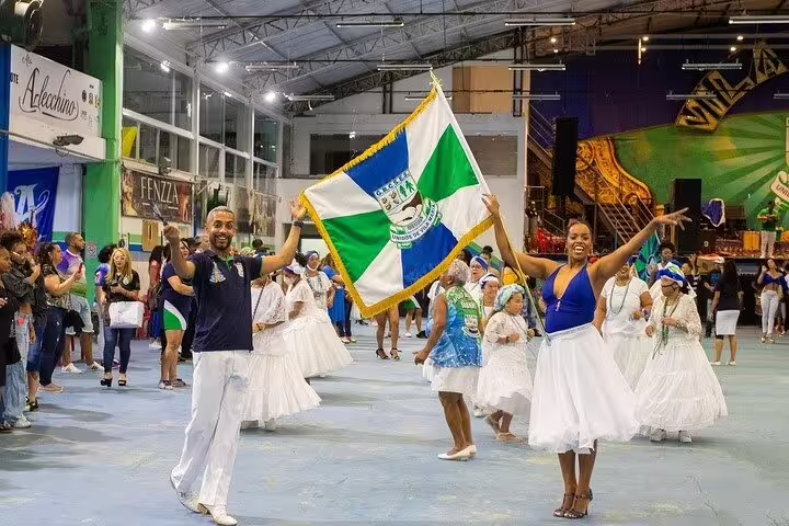 Vibrant São Paulo Carnaval rehearsal with samba dancers in traditional attire, featuring colorful flags and lively music.