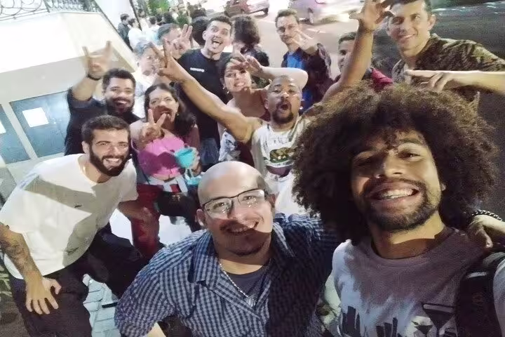 Excited group of friends taking a selfie on a bustling São Paulo street, enjoying the city's nightlife.