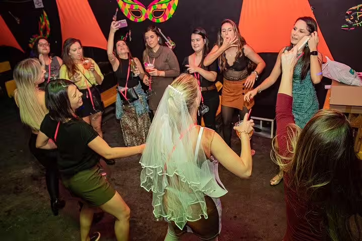Group of women dancing and celebrating at a São Paulo club, highlighting vibrant nightlife during a pub crawl.