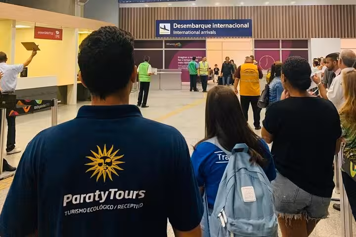 Passengers at international arrivals, greeted by Paraty Tours for São Paulo to Paraty shuttle service.