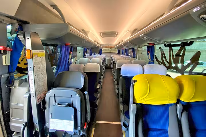 Interior view of a comfortable shuttle bus from São Paulo to Paraty, with plush seating and ample space.