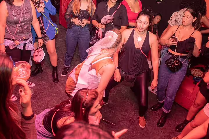 Group of friends dancing energetically at a lively pub in São Paulo during a vibrant nightlife experience.
