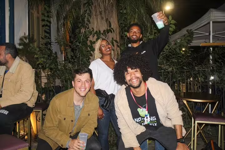 Happy group posing with drinks outside a popular São Paulo bar, capturing the essence of the city's nightlife.