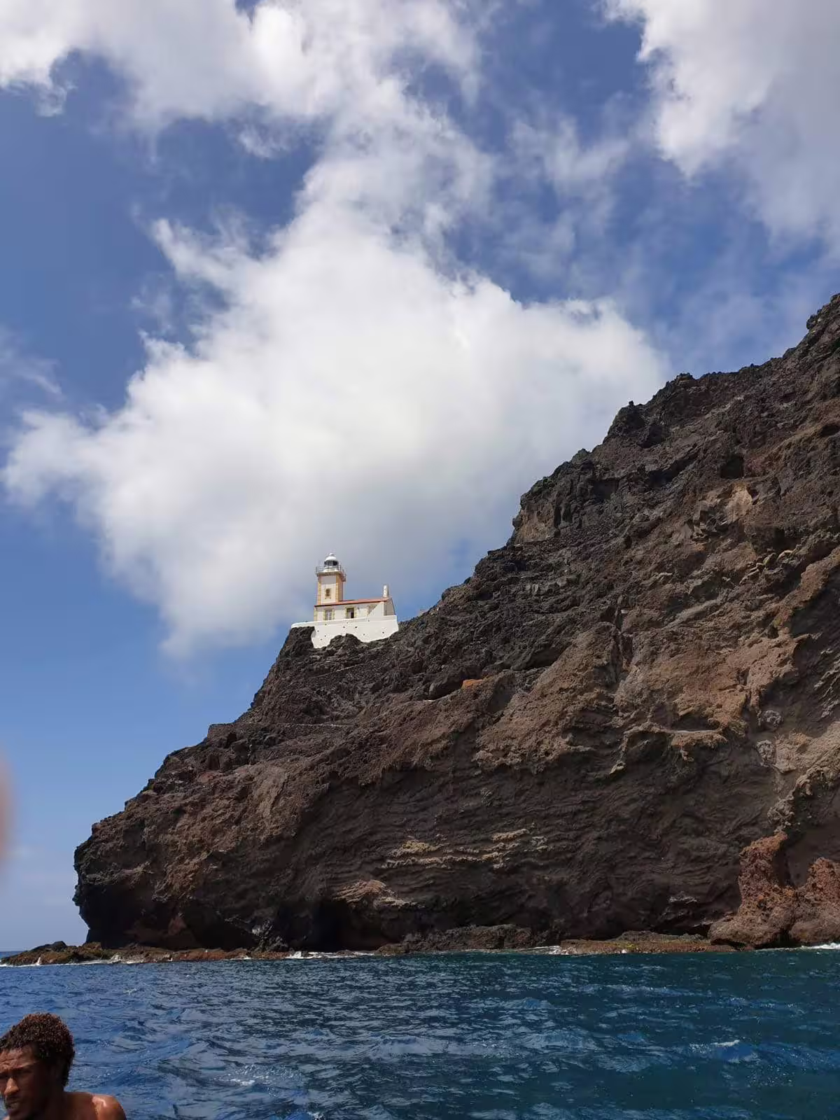 Dramatic cliffside view of a historic lighthouse overlooking the Atlantic Ocean on the São Vicente full-day tour.