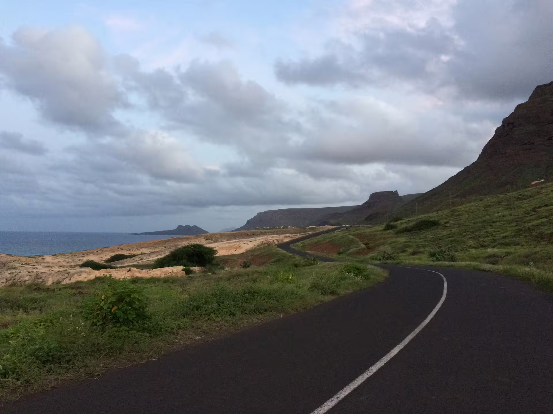 Scenic coastal road on São Vicente Island with lush greenery and dramatic cliffs, perfect for a full-day Mindelo tour.