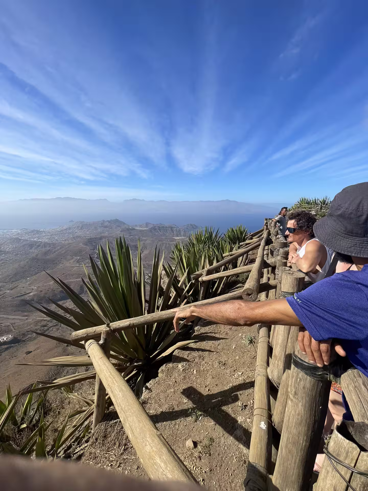 Tourists admire breathtaking views and lush plants from a scenic overlook during a São Vicente island tour in Mindelo.