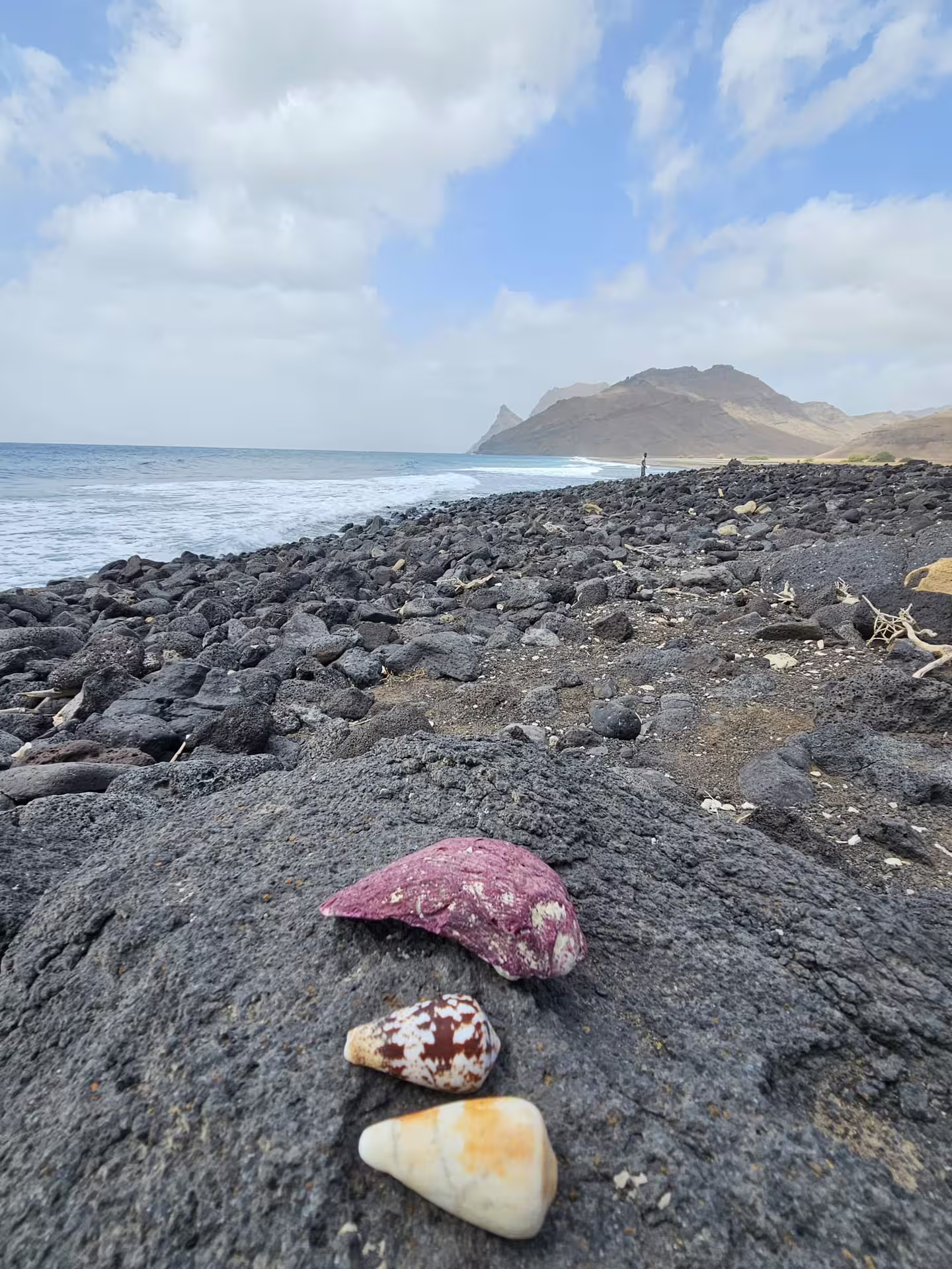 Scenic rocky beach with seashells in São Vicente, Cape Verde, offering stunning views of Monte Verde and coastal landscapes.