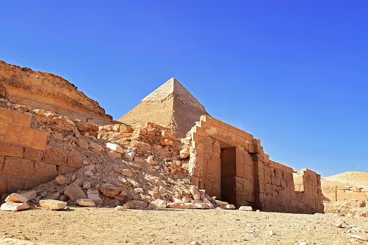 Ancient tomb ruins at Saqqara with pyramid in background on Royal Expedition tour from Cairo, Egypt