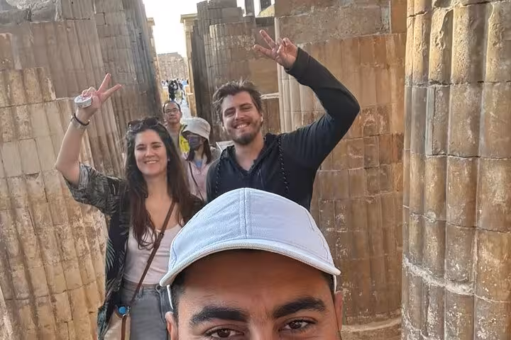 Travelers with guide in Saqqara ruins corridor during private tour to Memphis and Dahshur pyramids