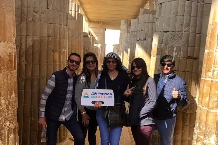 Happy travelers at Saqqara temple columns on private guided tour with transfers and lunch from Cairo