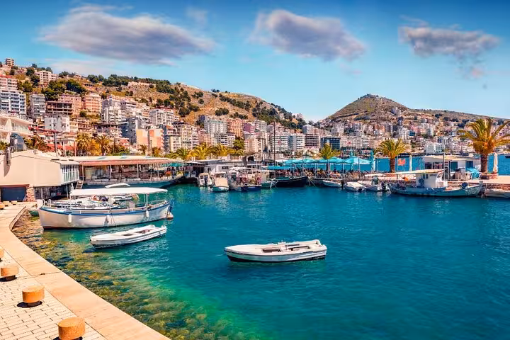 Scenic view of Saranda's vibrant harbor with boats and lush hills, perfect for a private guided tour in Albania.