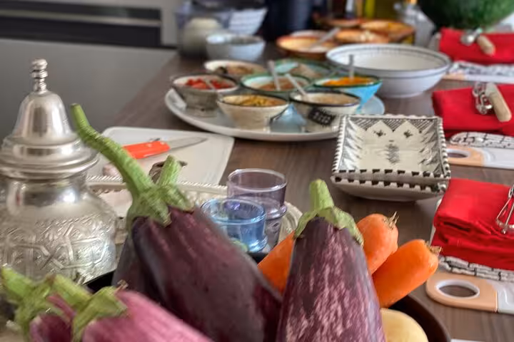 Fresh eggplants and ingredients laid out for a Sardin Tawa cooking class in Marrakesh, showcasing Moroccan culinary culture.