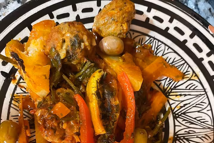 Vibrant Moroccan dish with sardines, colorful vegetables, and spices on a traditional plate at Marrakesh cooking class.