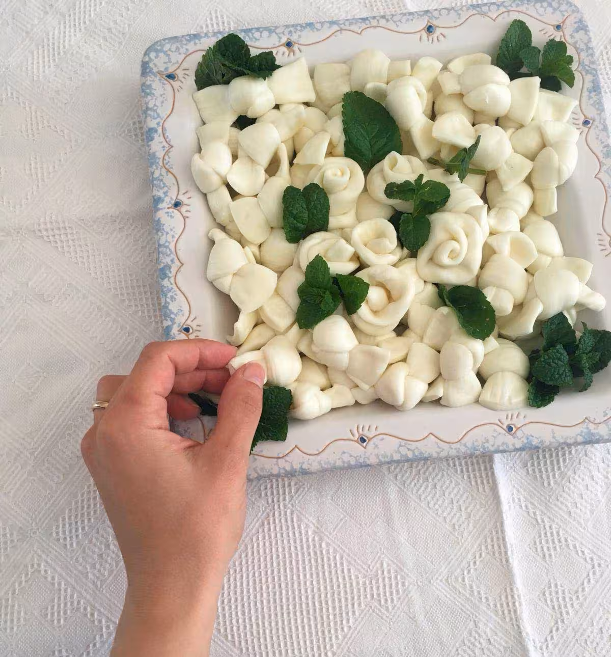 Plate of artisanal Sardinian cheese garnished with mint leaves, featured in the Dorgali crafts tour.