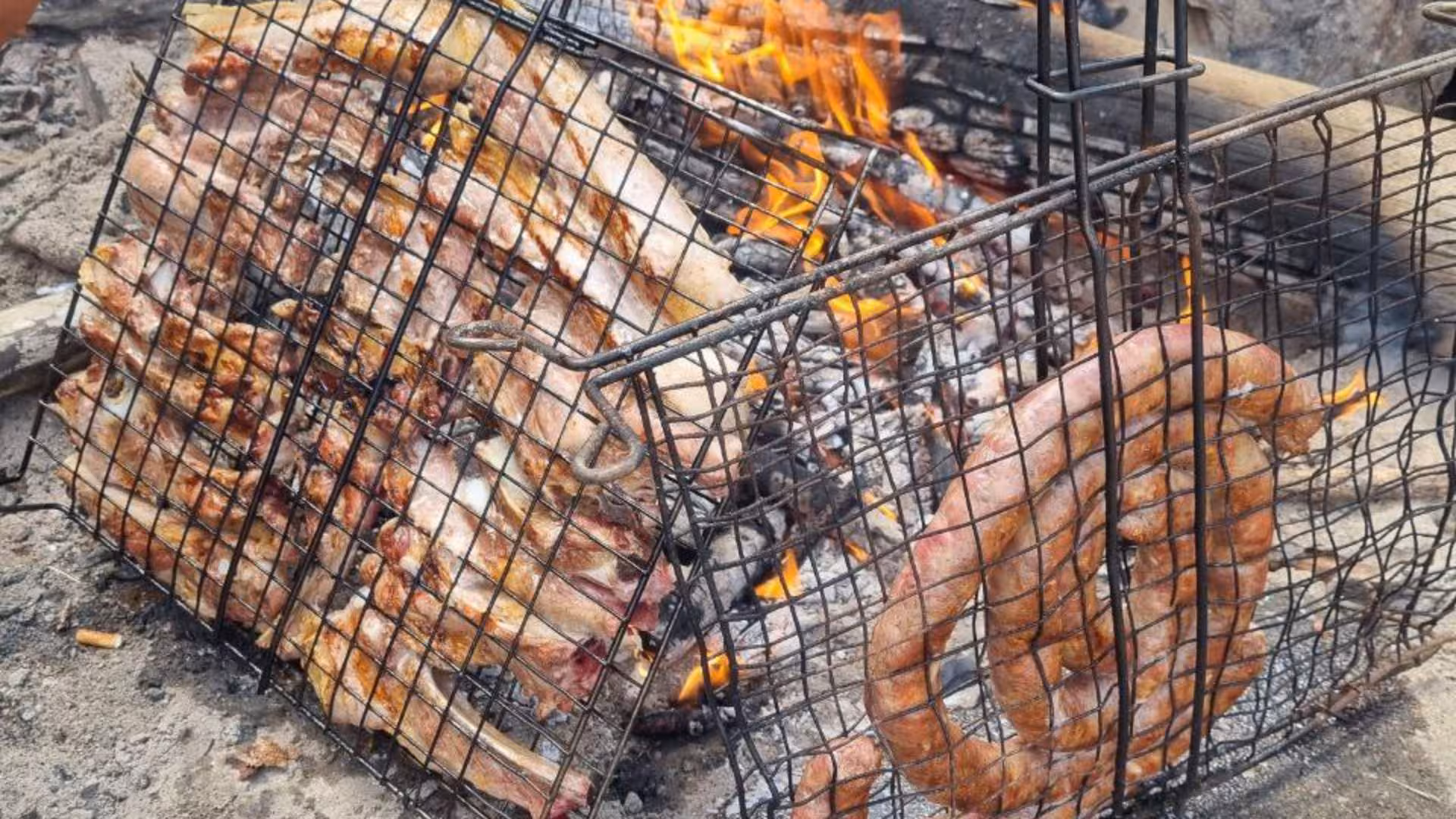 Traditional Sardinian barbecue with sizzling meat and sausages over open flames in Barbagia.