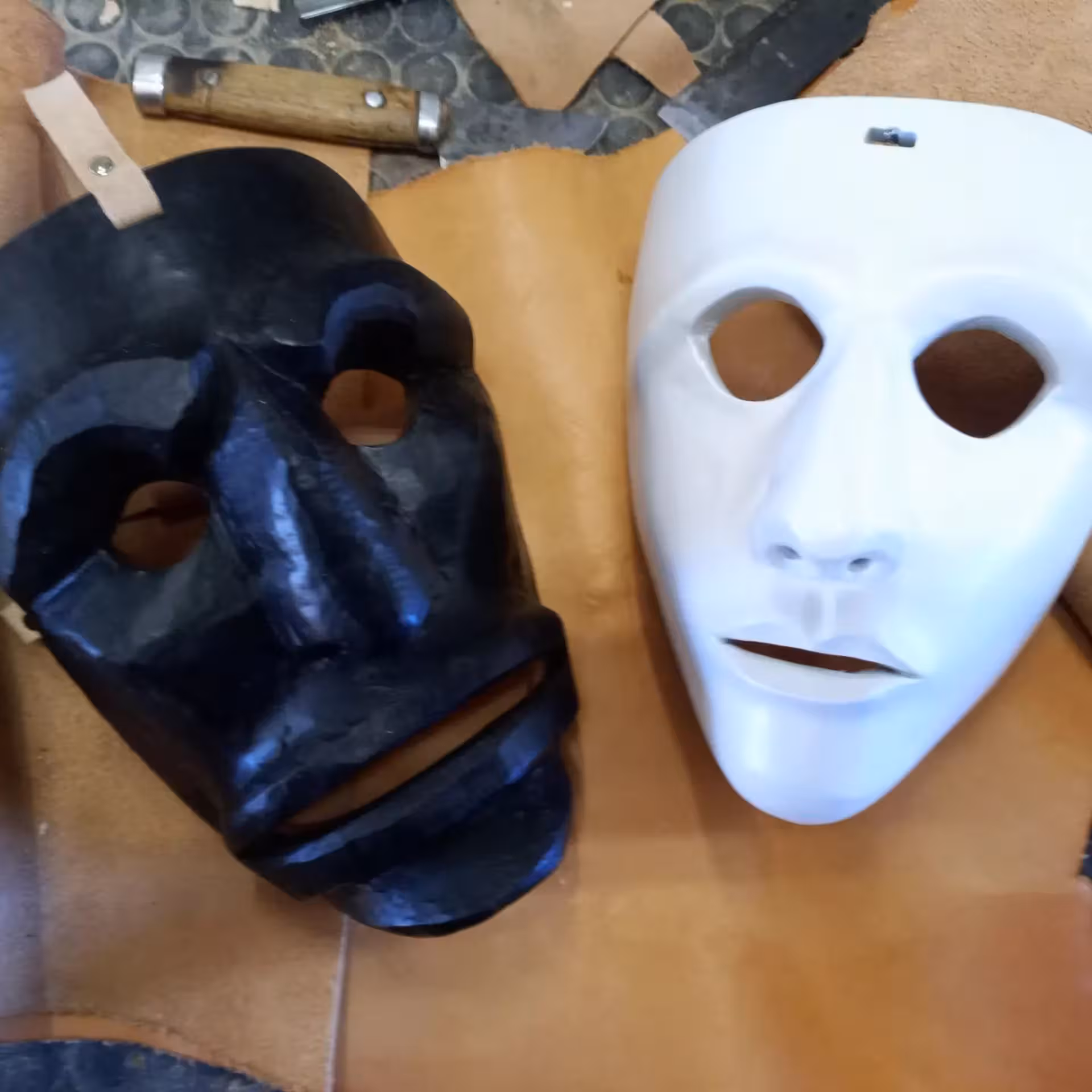 Traditional Sardinian black and white masks crafted at Mamoiada mask workshop in Italy.
