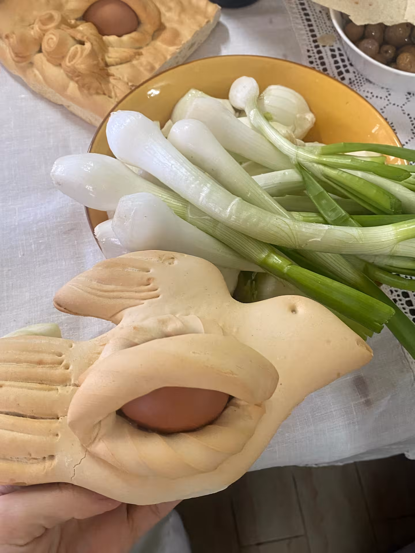 Traditional Sardinian bread with egg and fresh onions at Olbia pasta workshop in ancient village setting.