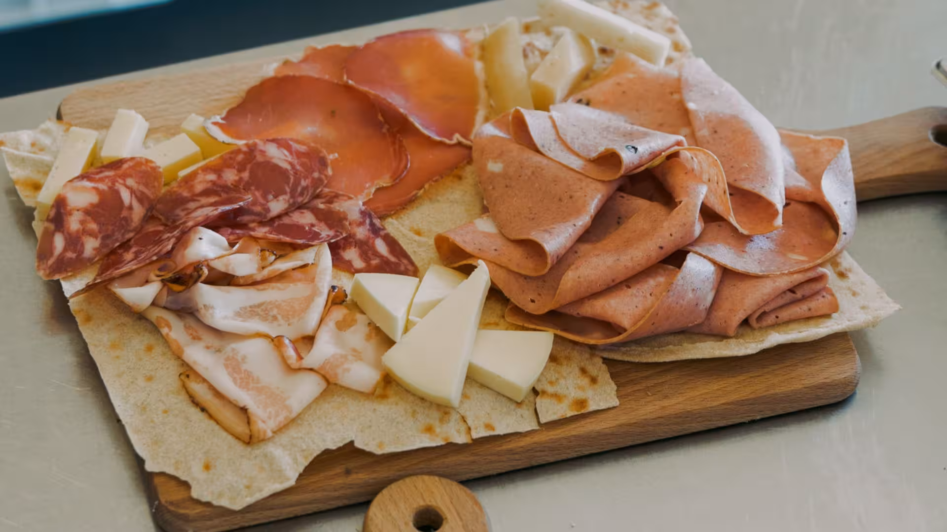 Traditional Sardinian charcuterie and cheese platter on a wooden board, highlighting local culinary delights.