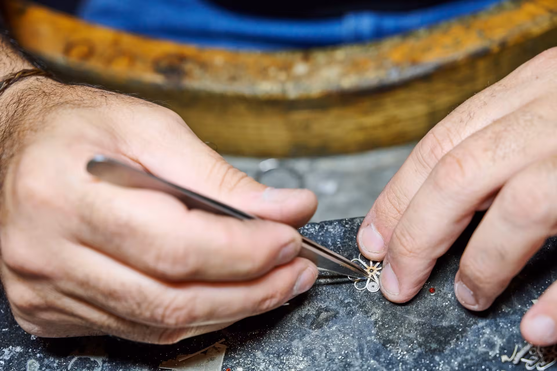 Close-up of a craftsman working on intricate Sardinian filigree jewelry in Dorgali, highlighting delicate craftsmanship.