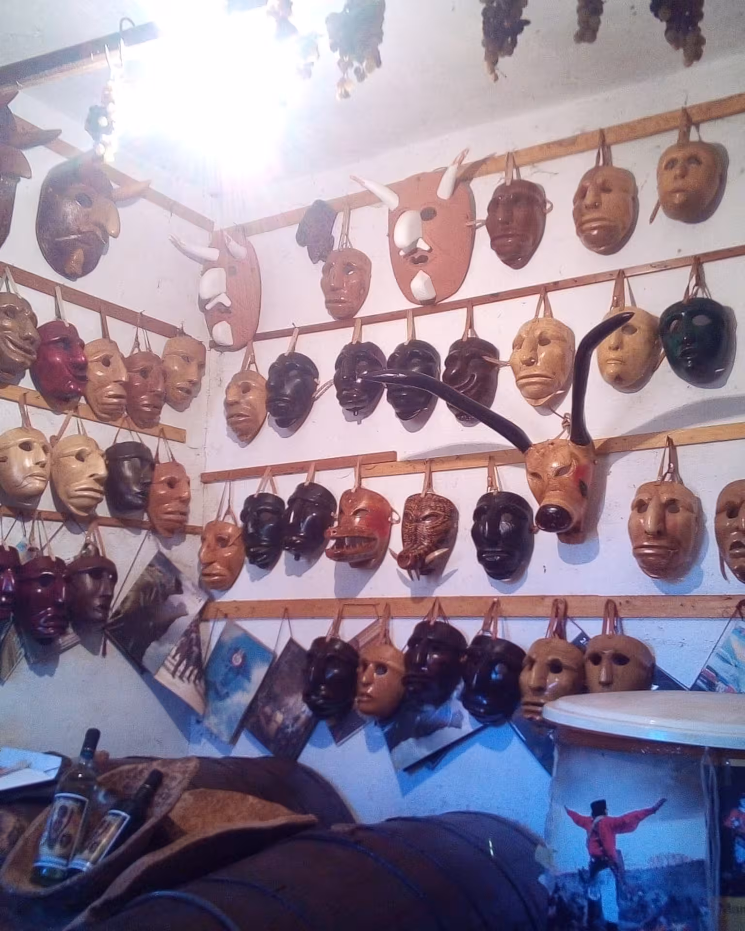 Explore the vibrant display of traditional Sardinian masks hanging in Mamoiada's authentic mask workshop.