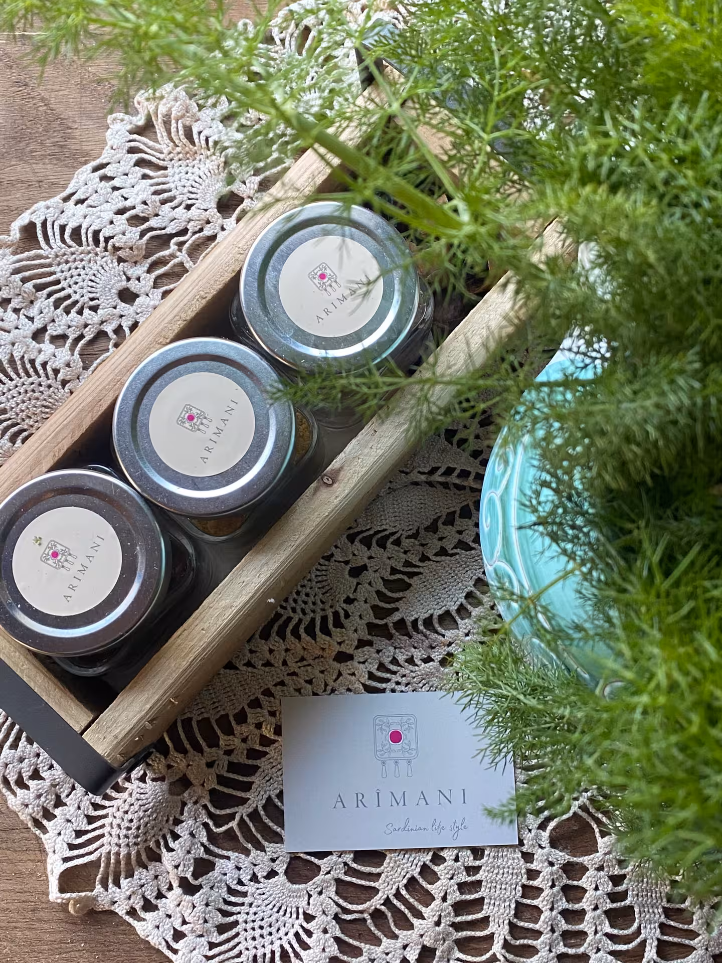 Artisan jars and lush greenery on a lace doily highlight the Sardinian lifestyle in Olbia pasta workshop.