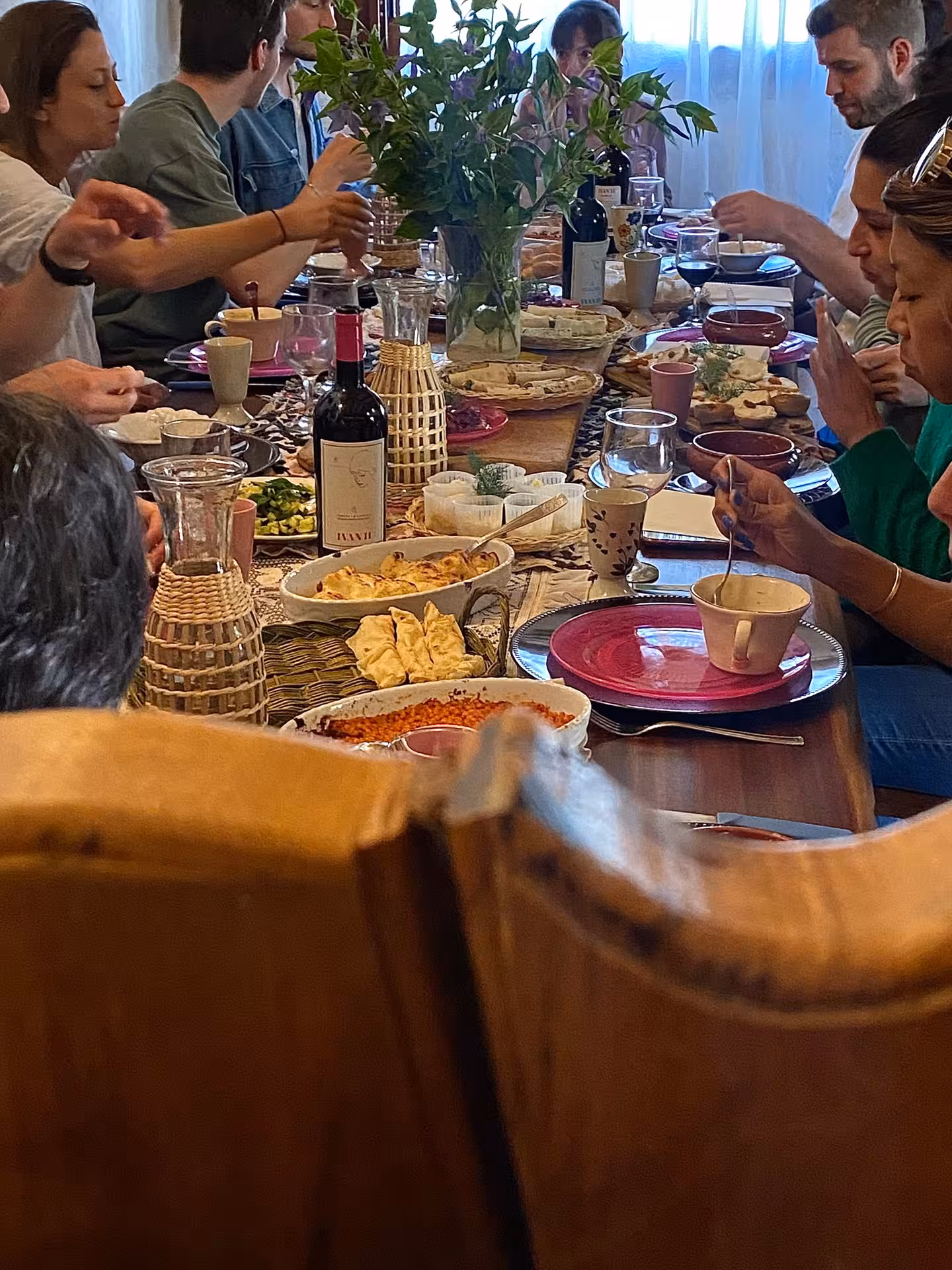 Group enjoying traditional Sardinian meal at a communal table during a pasta workshop in Olbia.