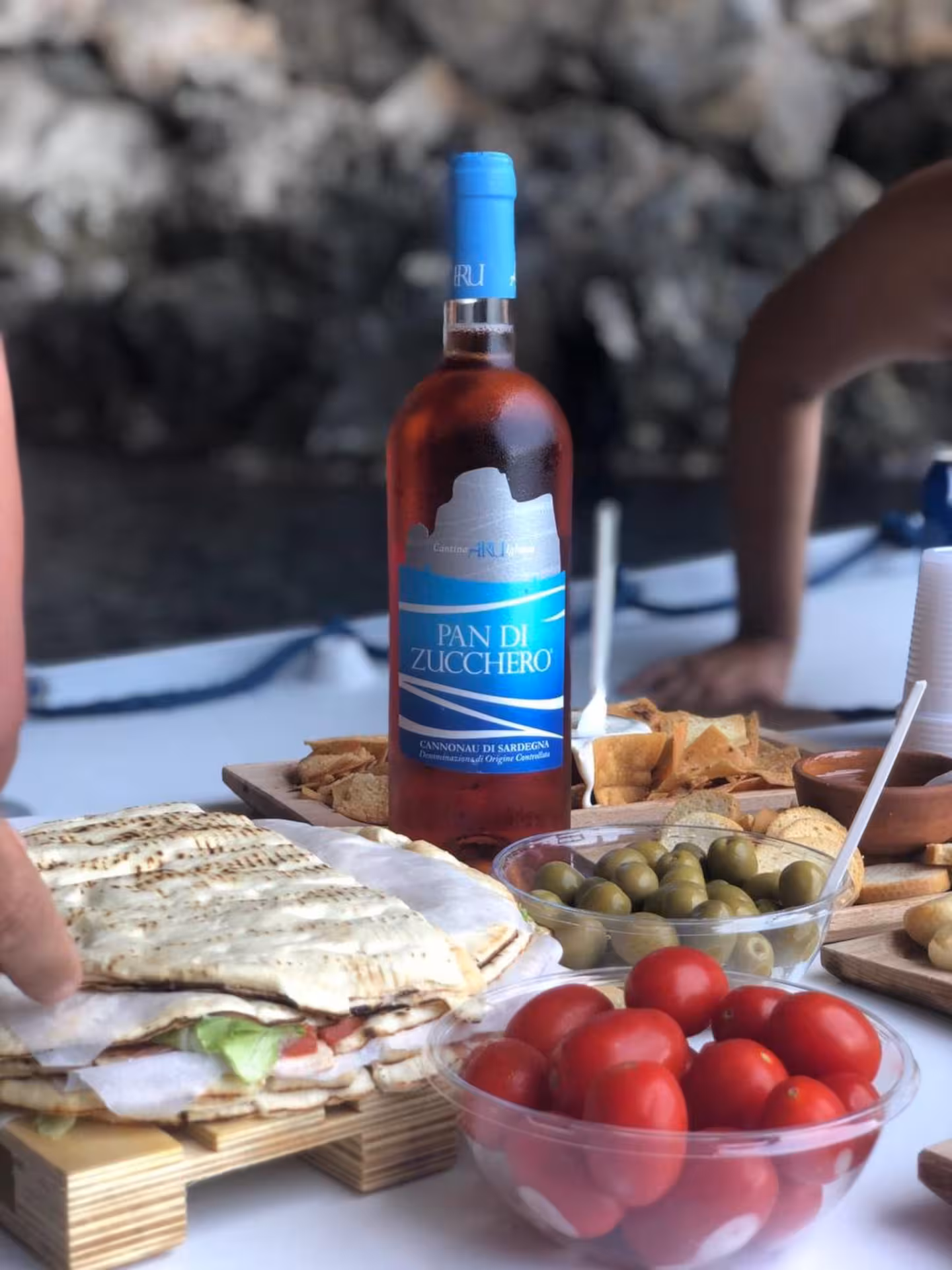 Authentic Sardinian snacks and wine on a RIB tour between Carloforte and Masua, highlighting local flavors.