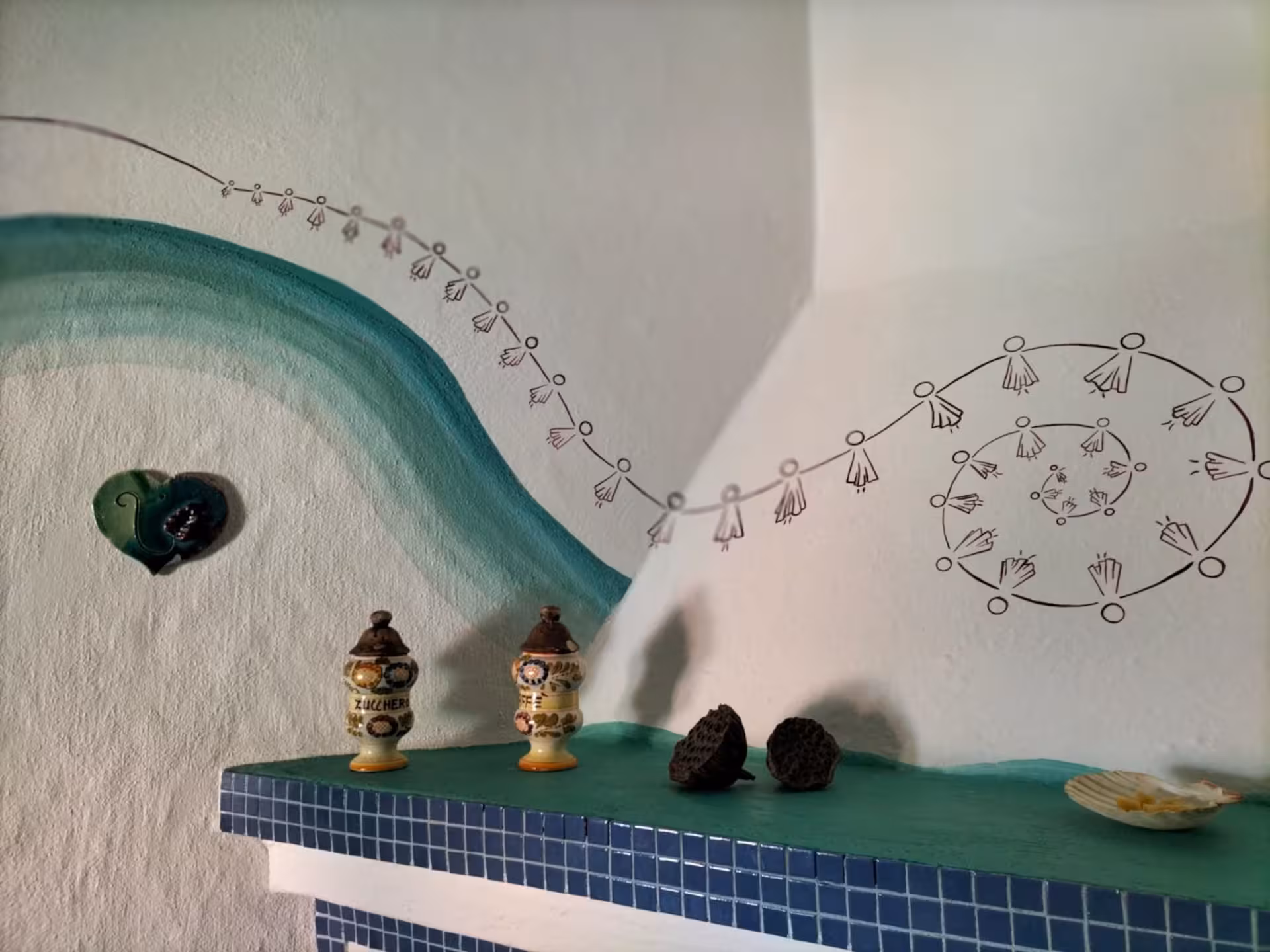 Artistic wall mural with intricate designs in a Sardinian weaving workshop, highlighting cultural motifs.