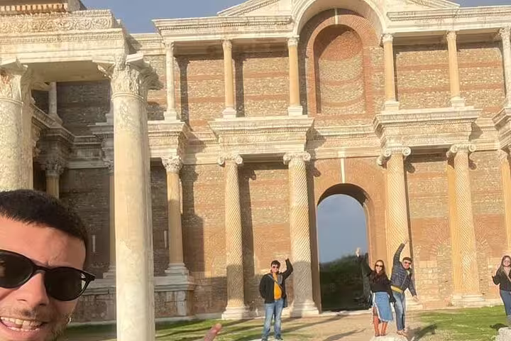 Tourists enjoy the historic facade of Sardis, part of the 4-day 7 Churches of Revelation Tour in Turkey.