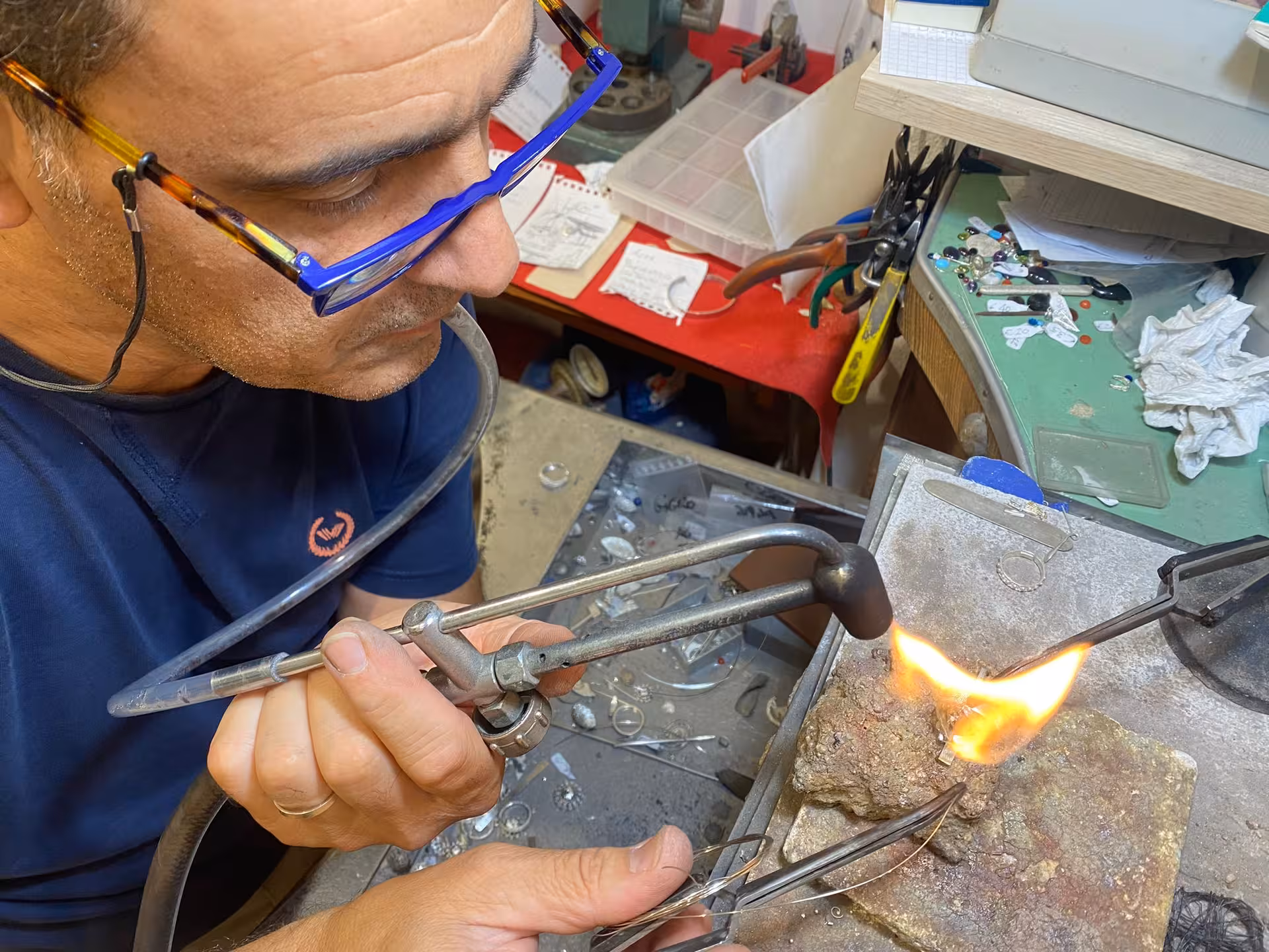 Artisan in Sassari skillfully soldering gold at a filigree workshop, showcasing traditional craftsmanship.