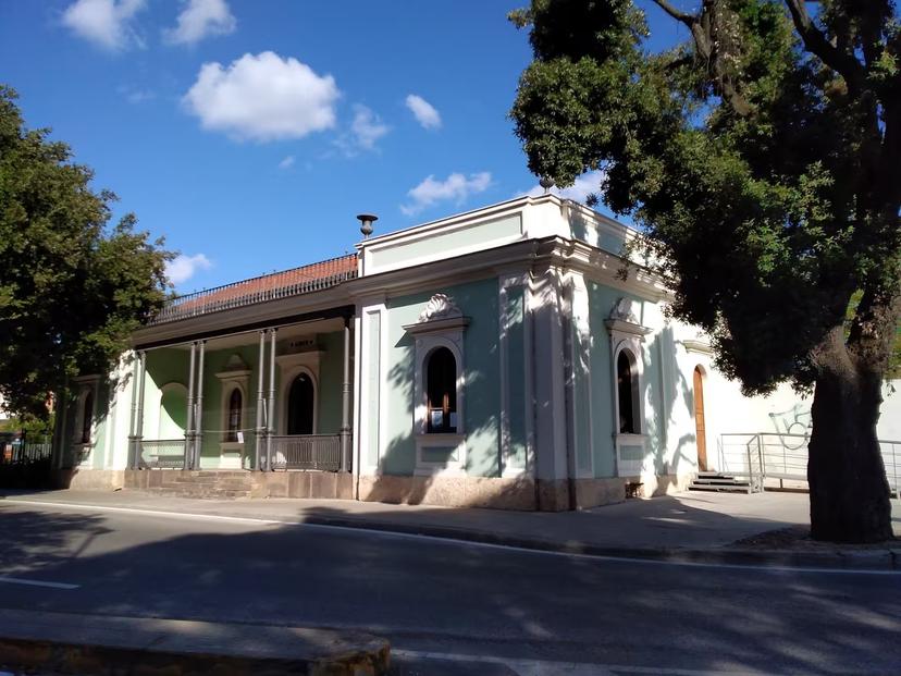 Historic building in Sassari under a clear blue sky, part of the Sea and Water Ecomuseum tour experience.