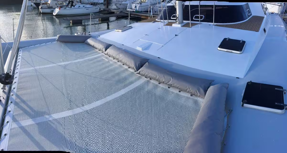 Relax on the catamaran Scarlett's expansive deck with cushioned seating, ideal for sunbathing and enjoying ocean views.