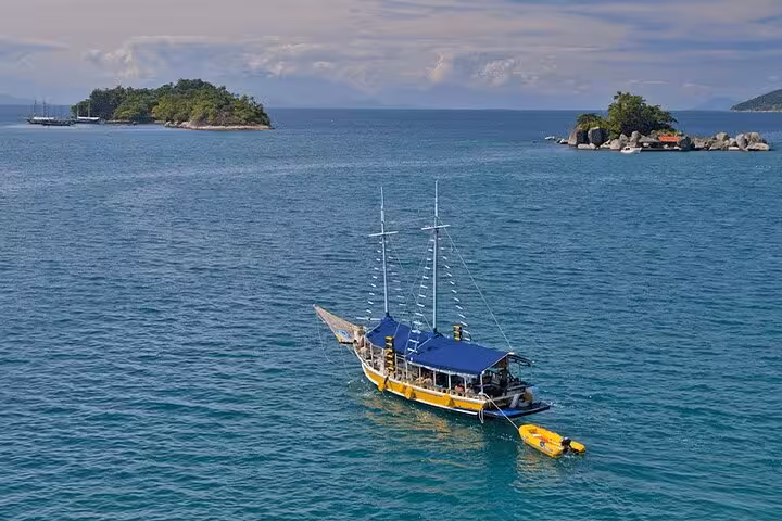 Schooner anchored near Paraty's islands, offering standup paddle and kayak services in crystal-clear waters.