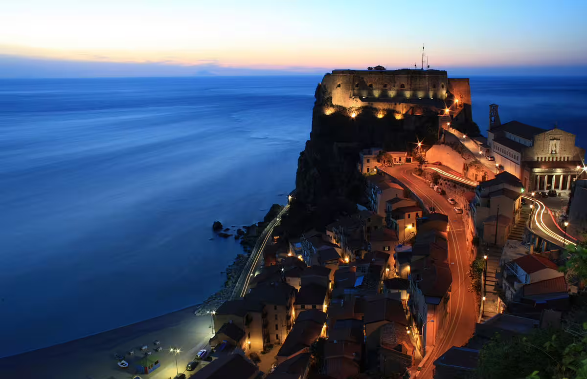 Twilight view of Scilla’s cliffside castle and coastal road in Calabria, Italy, on the Mediterranean Passion self drive tour