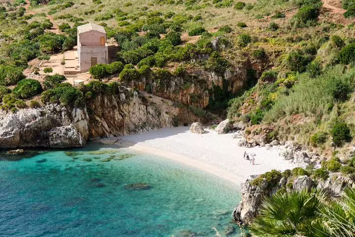 Secluded white-sand cove and historic building at Tonnara di Scopello on a private Palermo to Scopello day trip