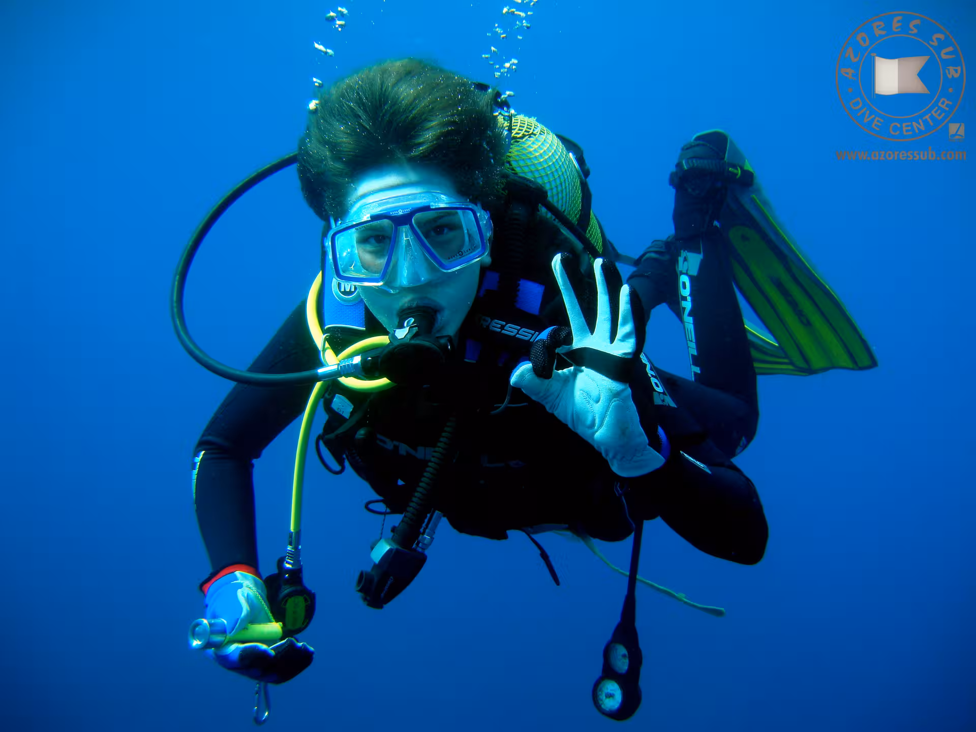 Scuba diver underwater giving OK sign during Baptism at Sea tour, guided ocean dive experience