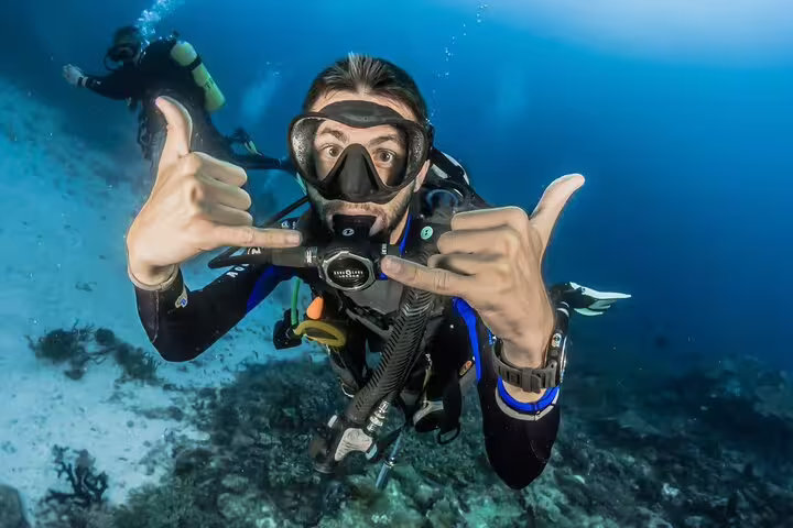 Scuba diver giving shaka sign above coral reef on Sharks Bay Diving Trip, Sharm El Sheikh Red Sea