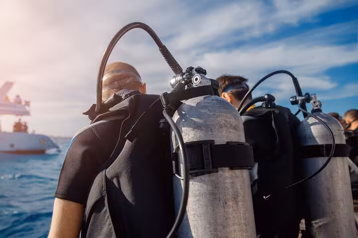 Scuba divers gearing up on a Hurghada dive boat with tanks, Red Sea day trip for beginners and certified