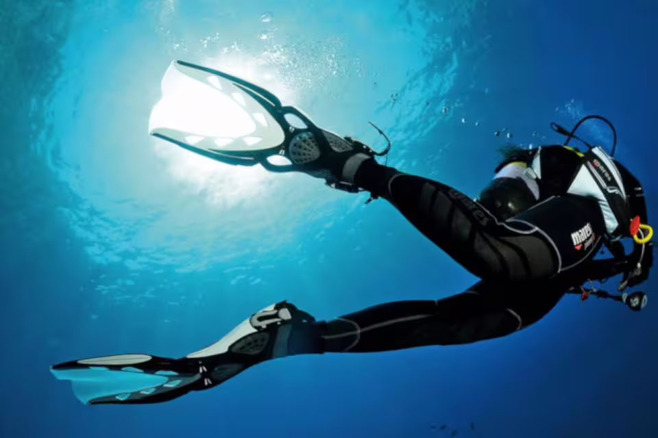 Scuba diver exploring clear blue waters in Funchal, showcasing underwater adventure and marine life discovery experience.