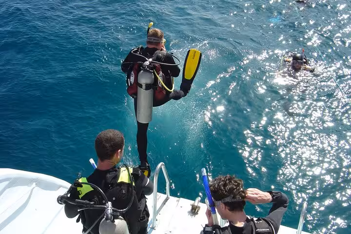 Divers entering the Red Sea from a Hurghada boat ladder, beginner and certified scuba diving day trip