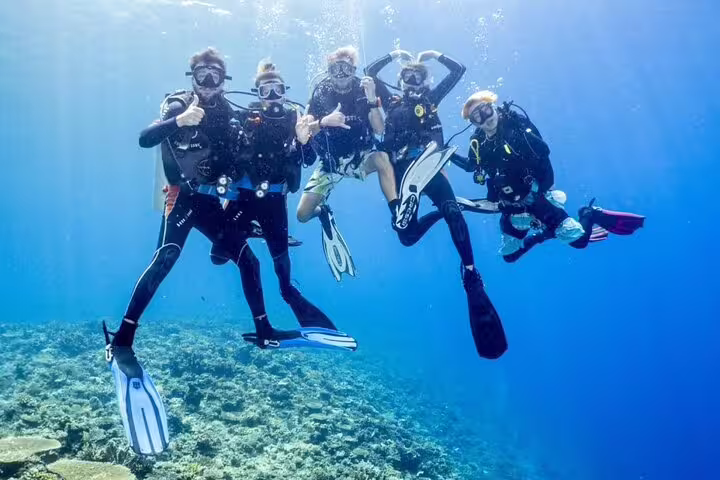 Group scuba diving in the Red Sea on a Hurghada VIP boat excursion, exploring clear water reefs