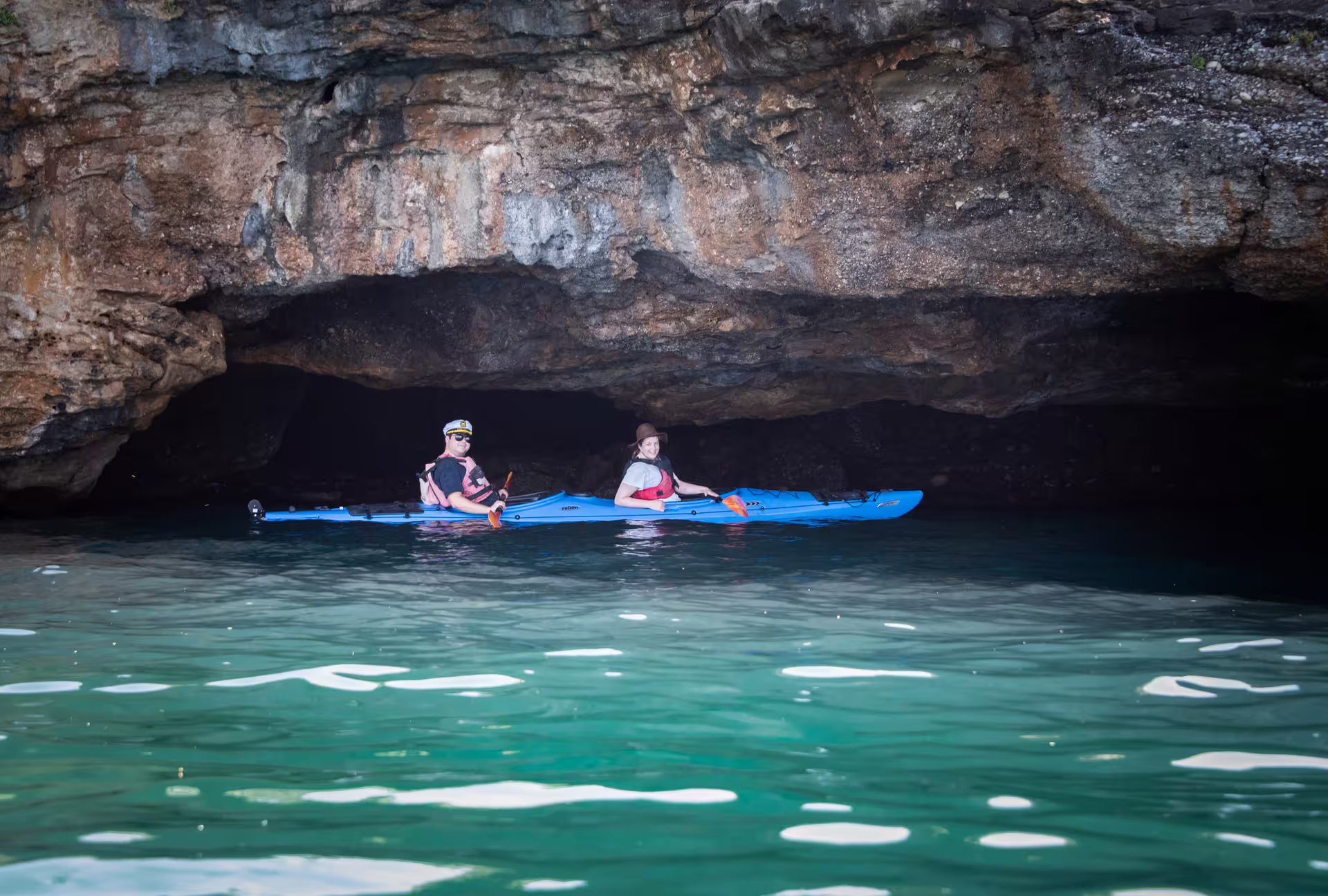 Two sea kayakers explore a coastal cave on a guided sea kayak tour in Kalamata, Messinia, Greece