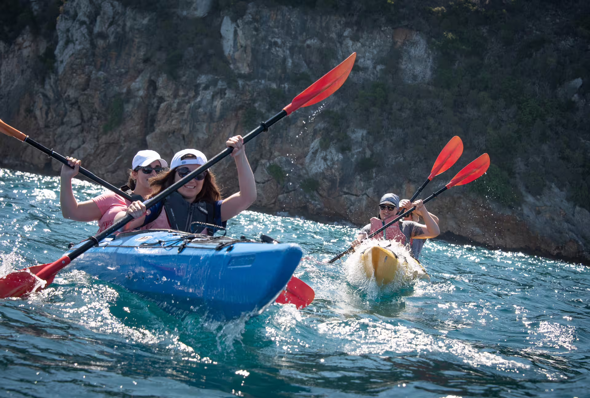 Adventurous sea kayaking in Navarino Bay with paddlers splashing through waves along rugged Messinia coast