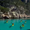 Guided sea kayaking in Calanques de La Ciotat, paddlers on turquoise water beneath limestone cliffs