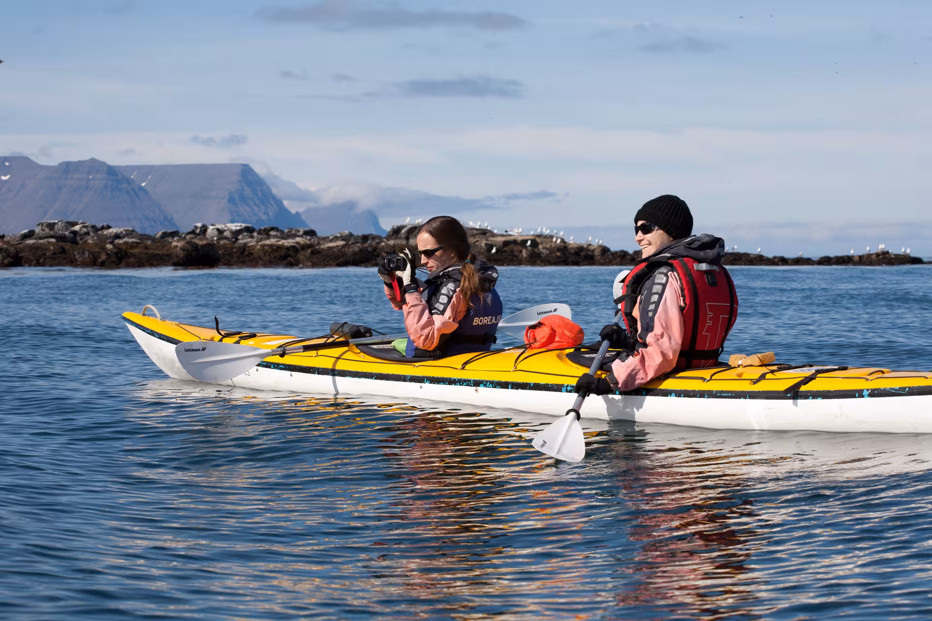 Two kayakers photographing seabirds from a tandem sea kayak on Seabird Discovery coastal wildlife tour