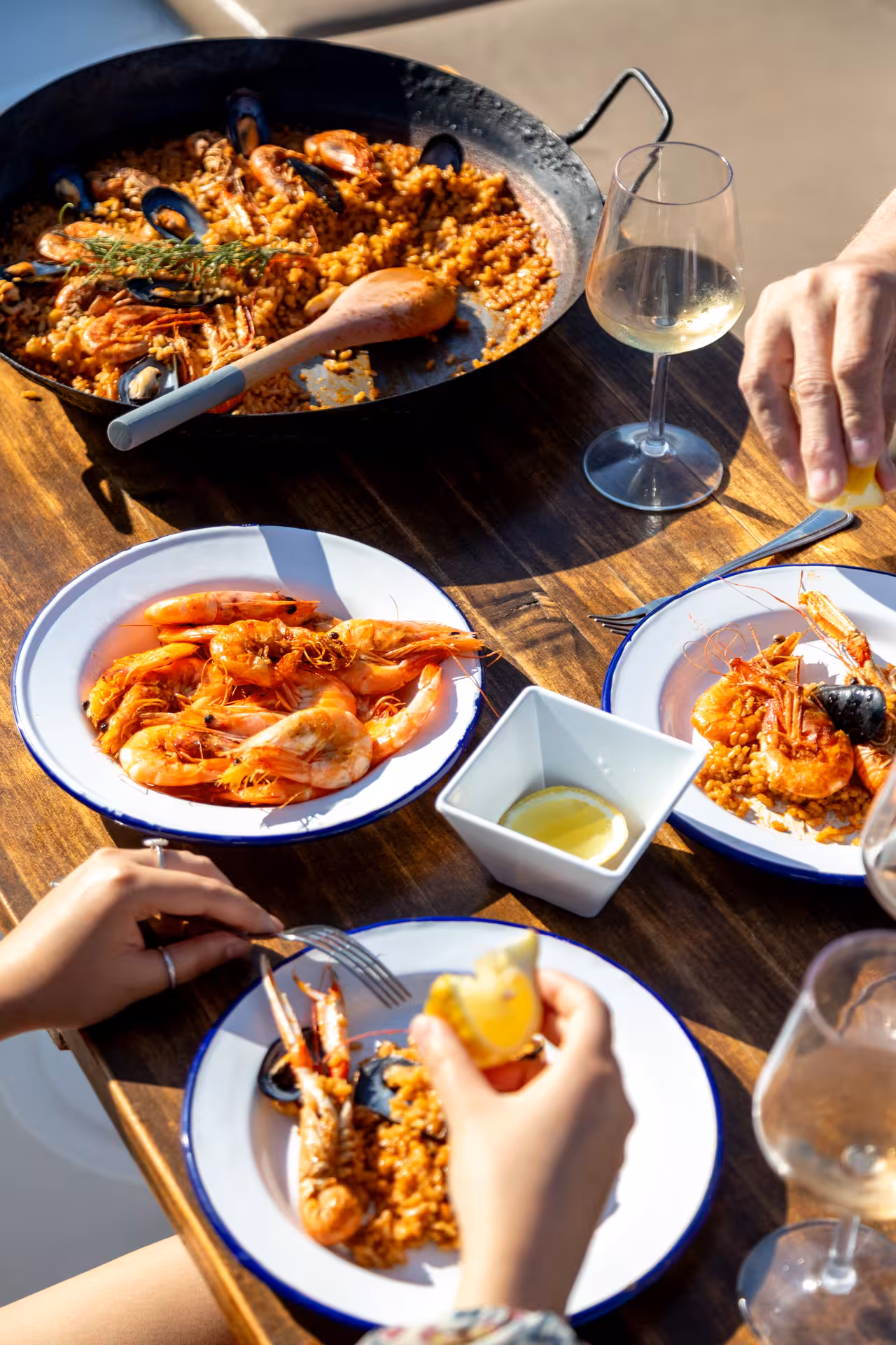Seafood paella pan with prawns and mussels served with white wine and lemon during a hands-on paella masterclass